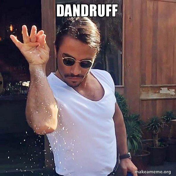 Man wearing sunglasses and a white t-shirt sprinkling white flakes with the word 'DANDRUFF' above him in bold white text.