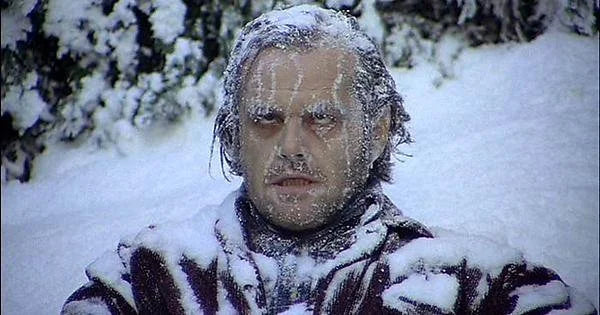 A person with hair and eyebrows covered in frost and snow, illustrating extreme cold and dryness affecting the scalp in winter.
