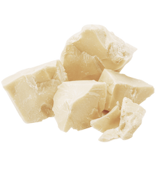 Close-up of cocoa butter chunks showing creamy pale yellow texture on white background