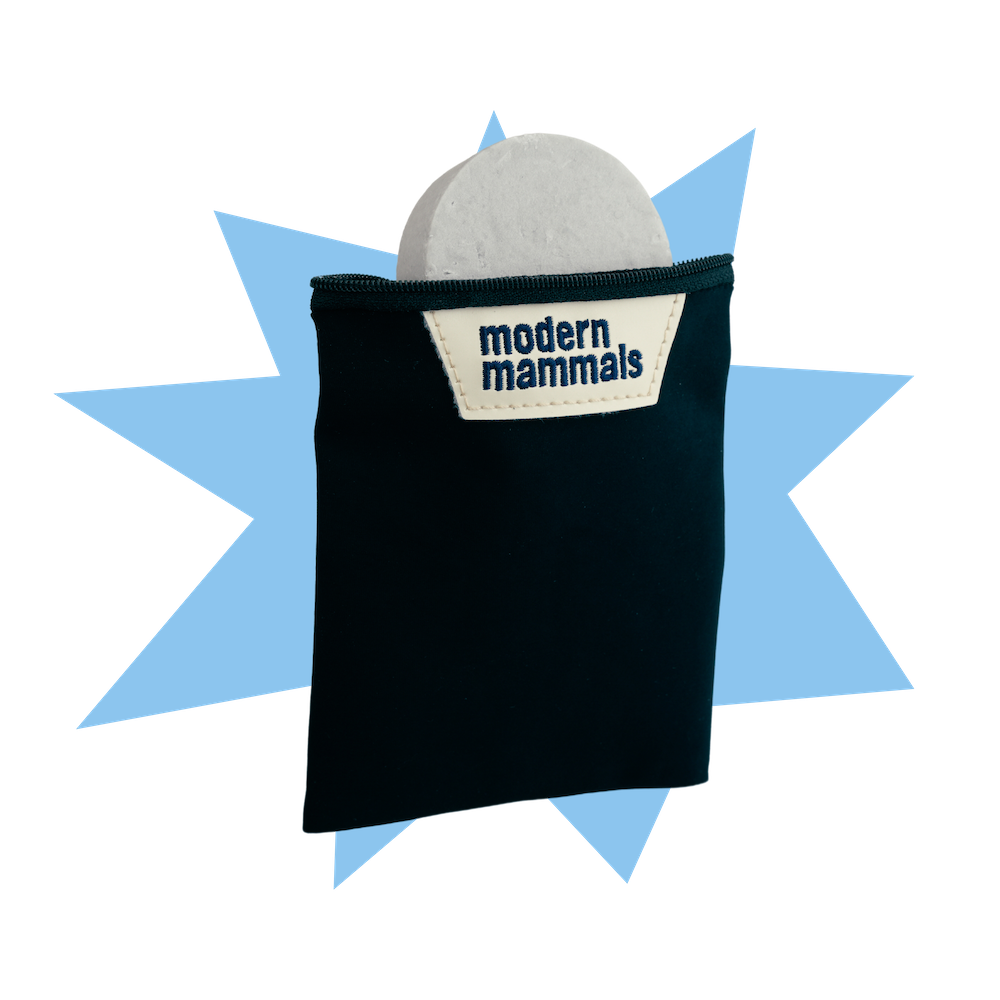 Front of Bar Travel Bag with shampoo bar visible, black pouch and Modern Mammals label on blue starburst background