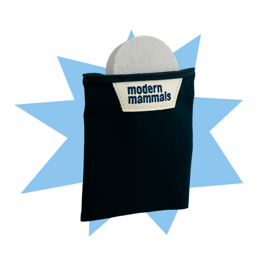 Front of Bar Travel Bag with shampoo bar visible, black pouch and Modern Mammals label on blue starburst background