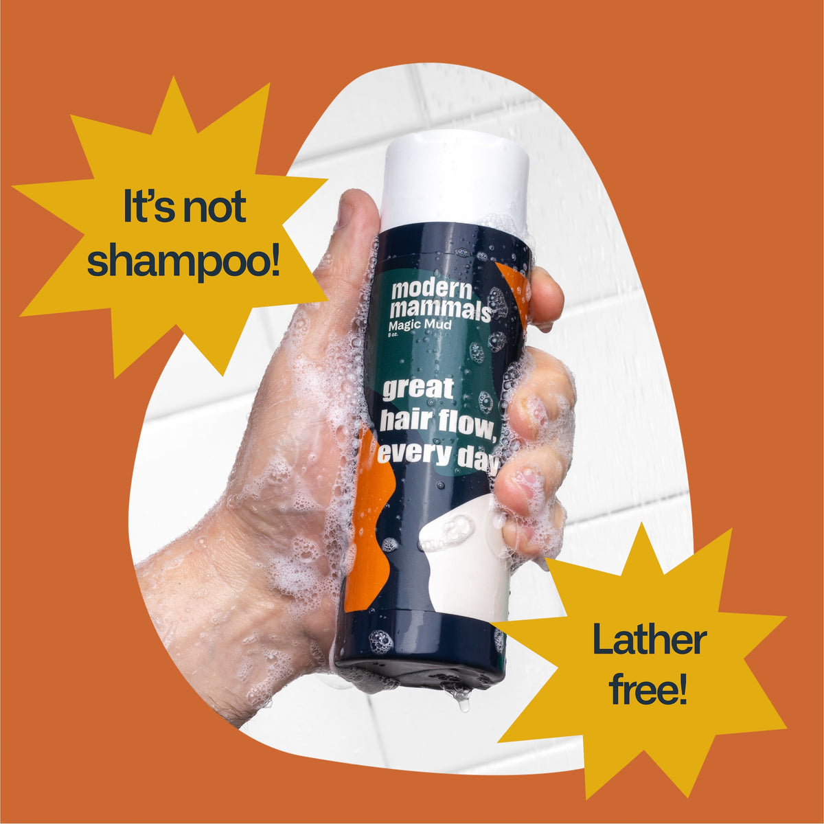 Hand holding modern mammals Magic Mud bottle labeled 'great hair flow, every day'; stars read 'It's not shampoo!' and 'Lather free!'