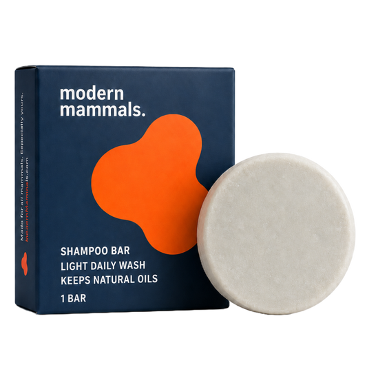 Front view of Shampoo Light Bar showing navy box with orange logo and round pale bar on white background