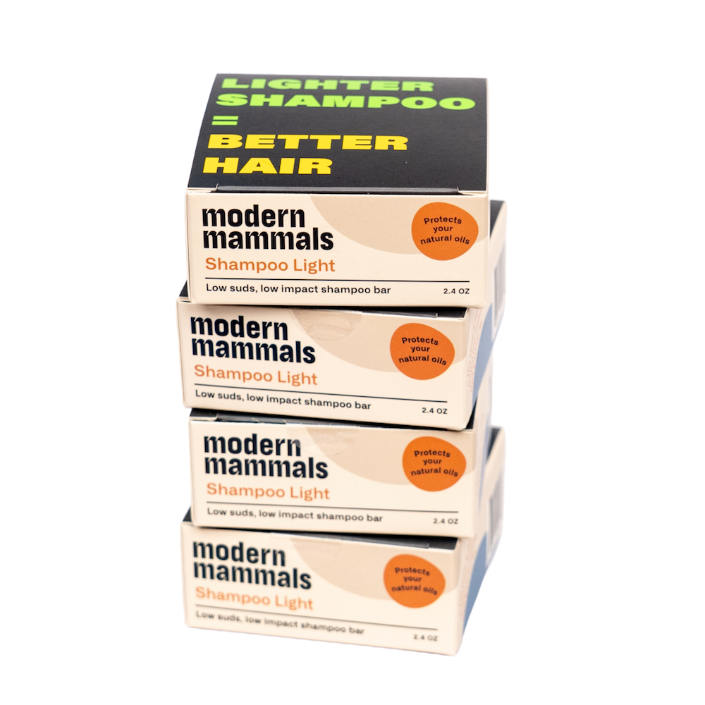 Front view of four stacked Modern Mammals Shampoo Light bars with Lighter shampoo equals Better hair and 2.4 oz on white